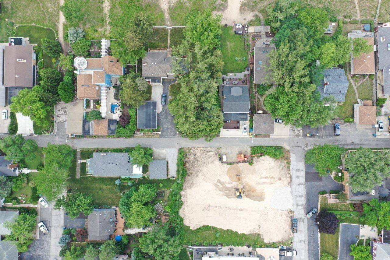 Aerial view of residential neighborhood with houses and a vacant lot.