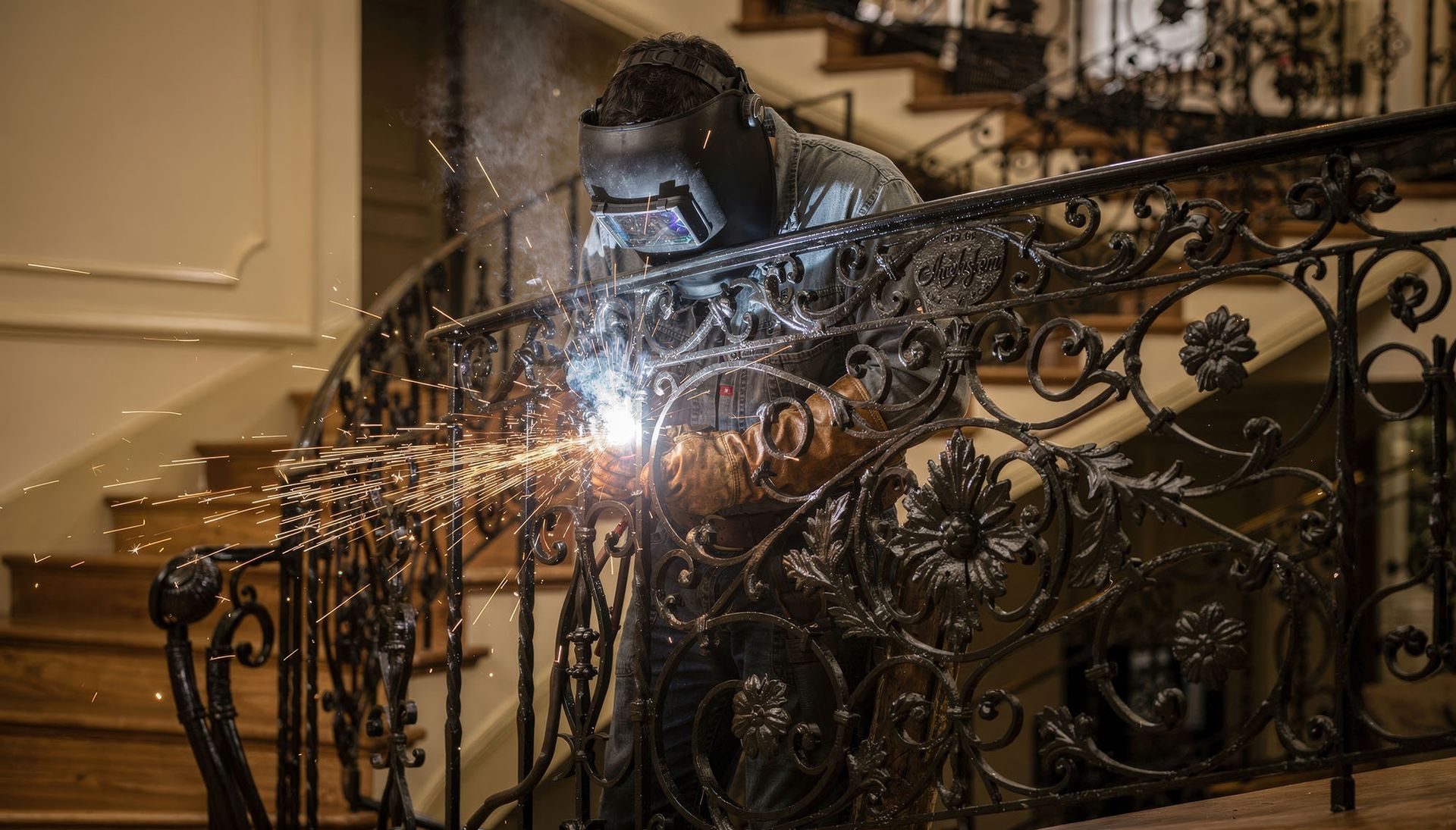 Crafting decorative wrought iron railings with custom scrollwork during fabrication.