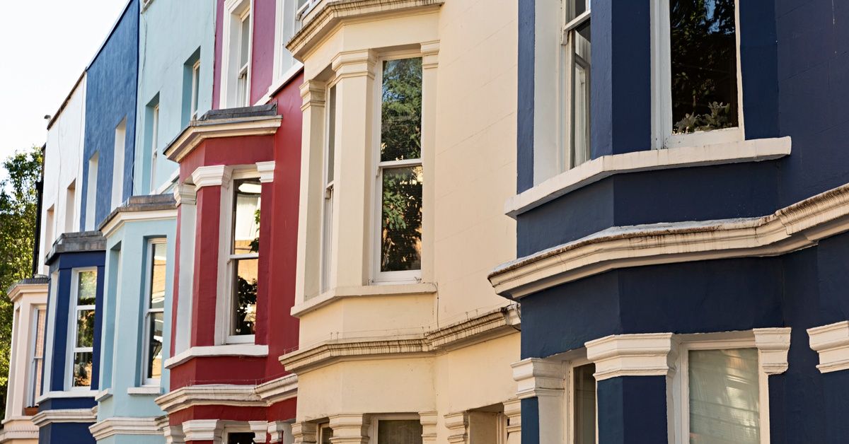 A row of six homes, all with the same architectural design, in red, white, and blue.