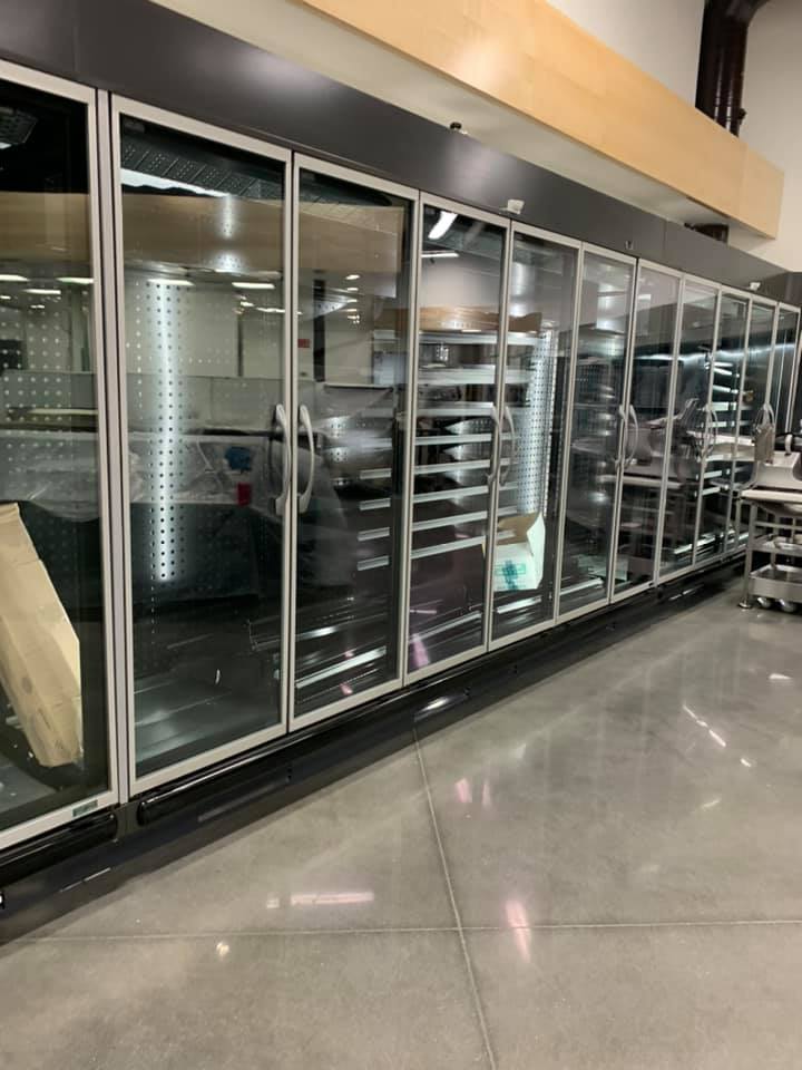 Large refrigerated glass door display case in a grocery store.