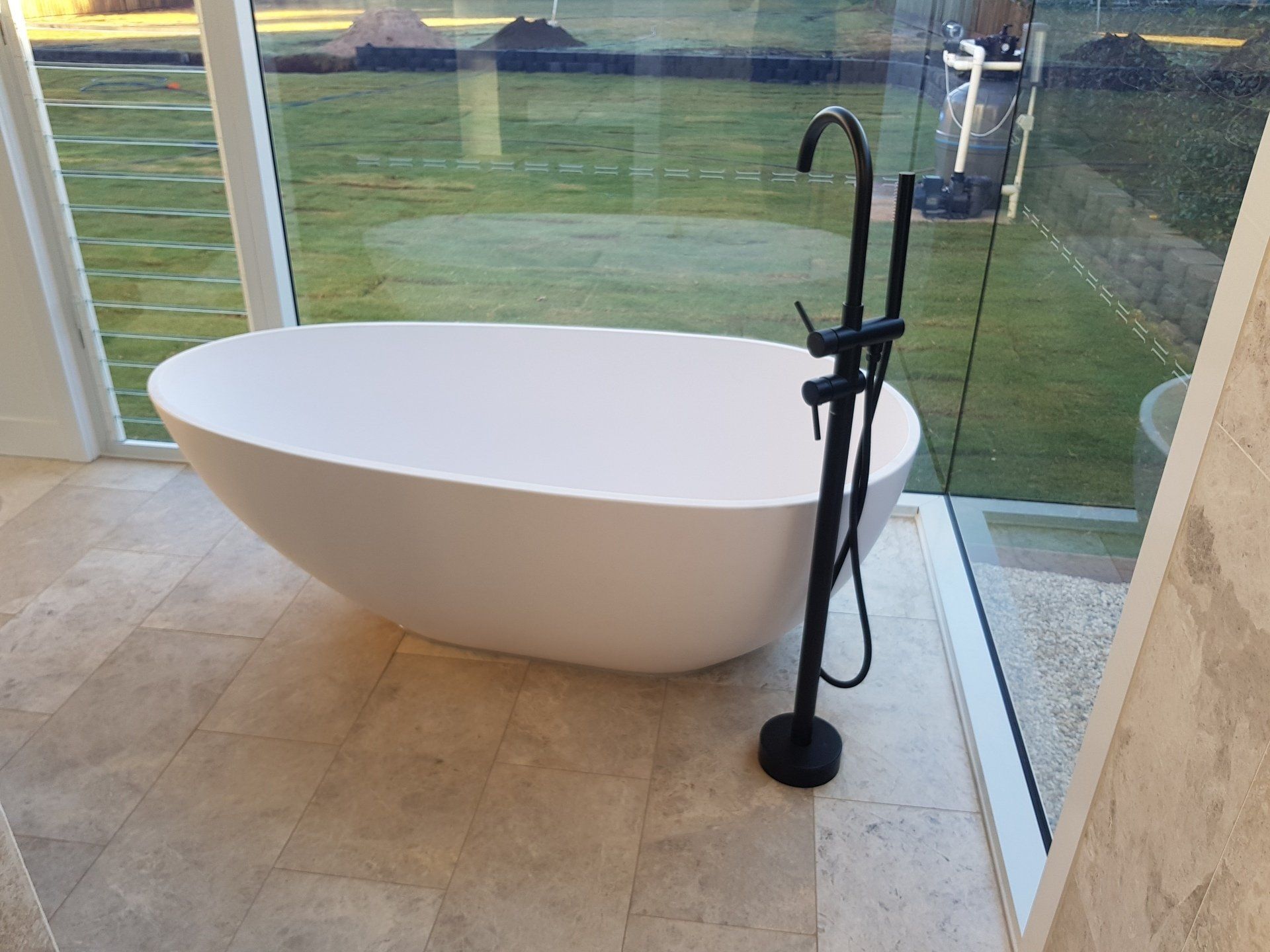 Man Installing induction Stove In Kitchen — Plumbers & Gasfitters In Highfields, QLD