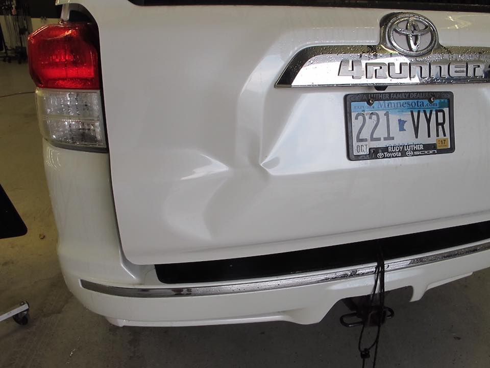 A white toyota 4runner with a damaged bumper