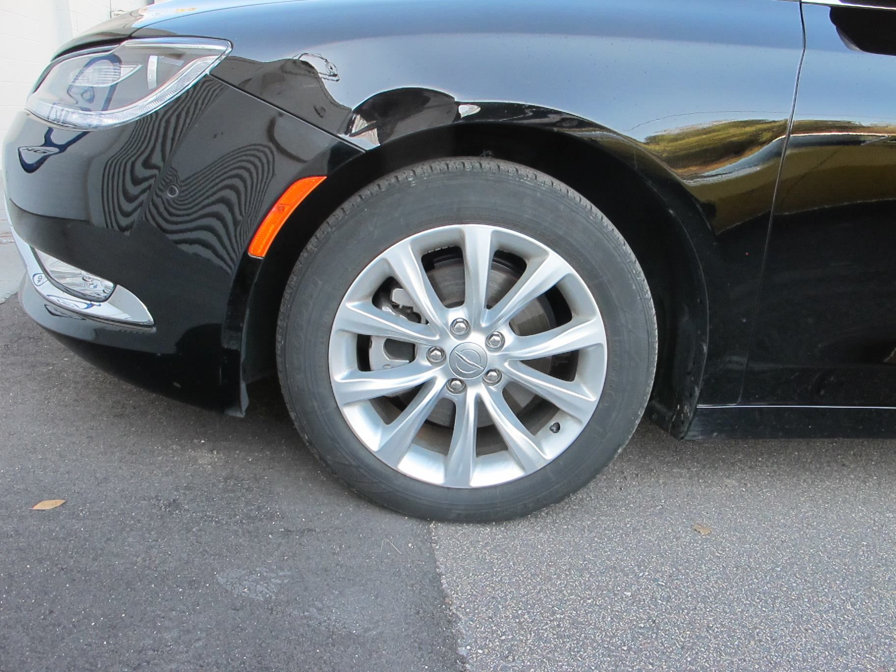 A black car is parked on the side of the road.