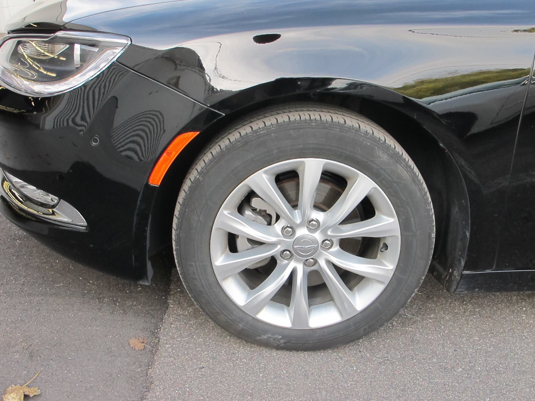 A black car is parked on the side of the road.