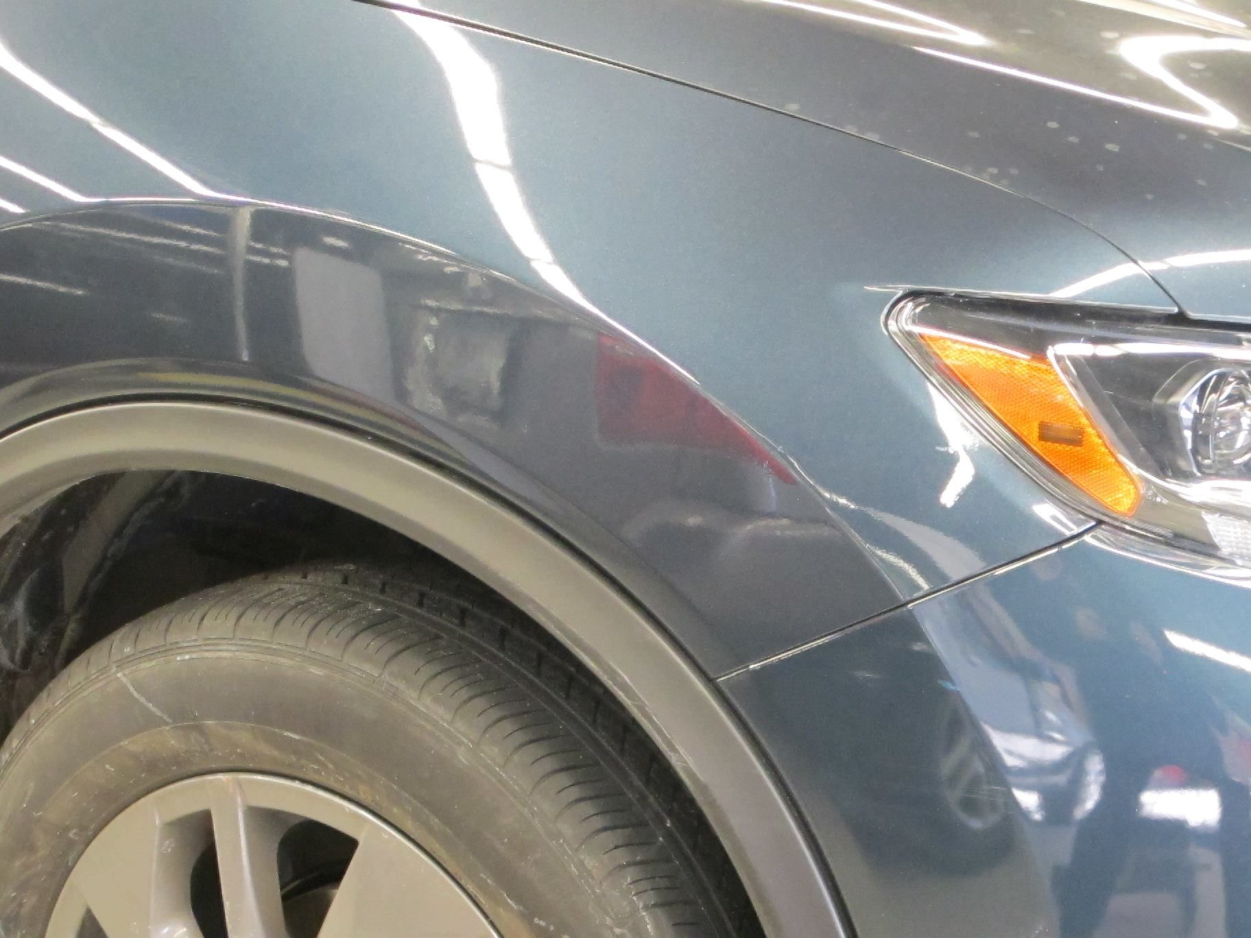 A close up of a car 's fender and tire