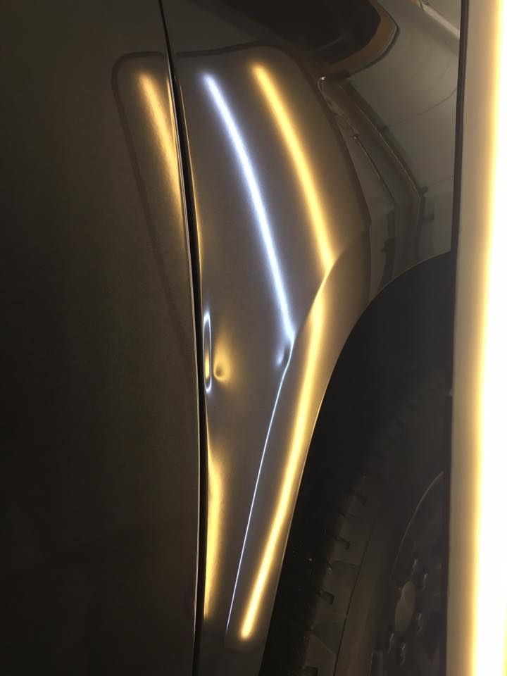 A close up of a car fender with a light coming out of it