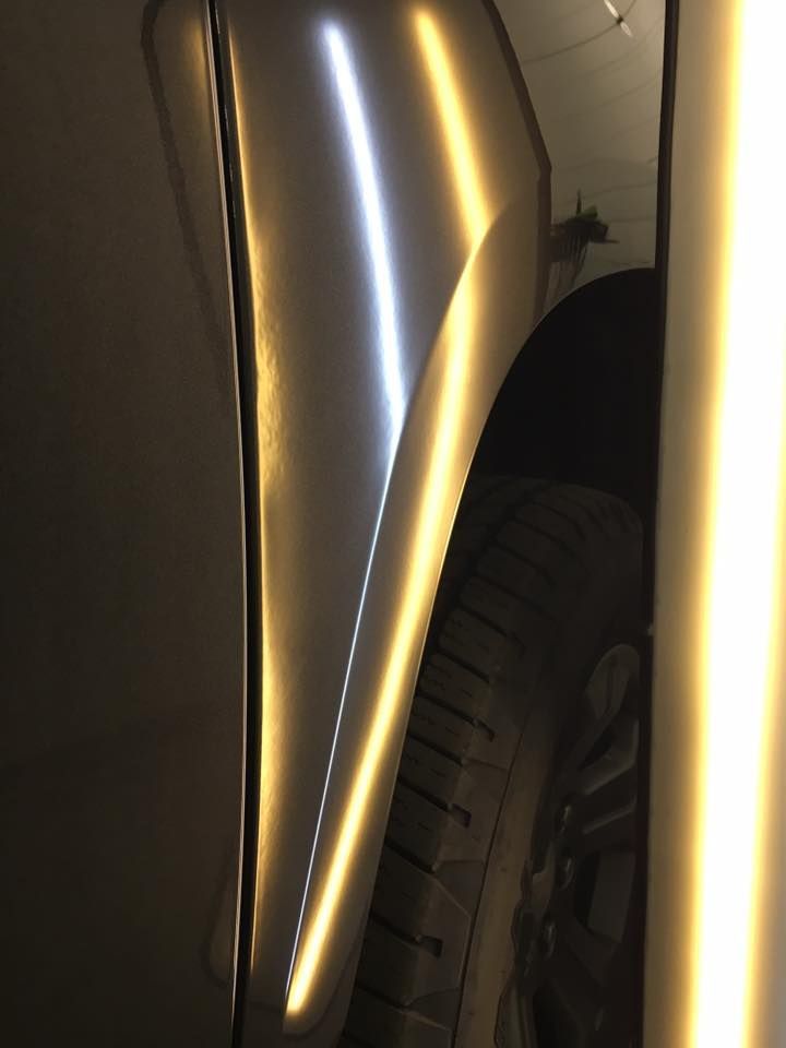 A close up of a car fender with a light coming out of it