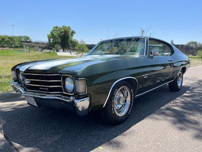 A green chevrolet chevelle is parked on the side of the road.