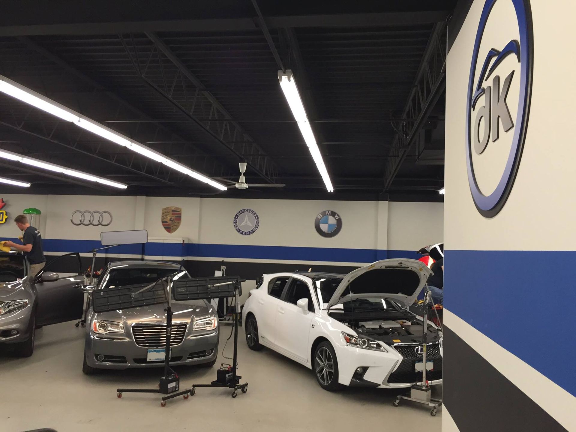 Cars are being worked on in a garage with the word ok on the wall