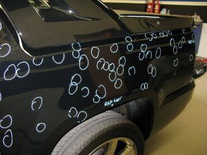 A black car with a lot of dents on it