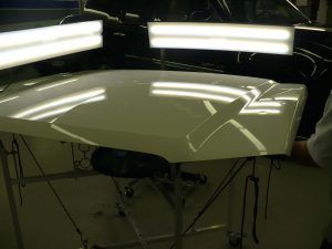 A person is standing next to a white table with lights on it.
