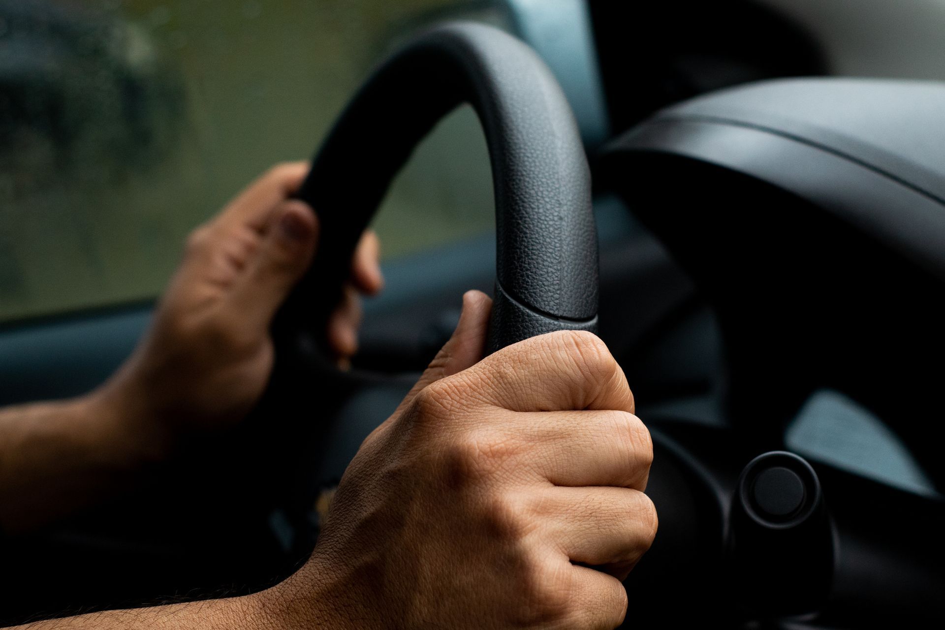 Focused close-up of hand navigating steering wheel. Focused close-up of hand navigating steering wheel.