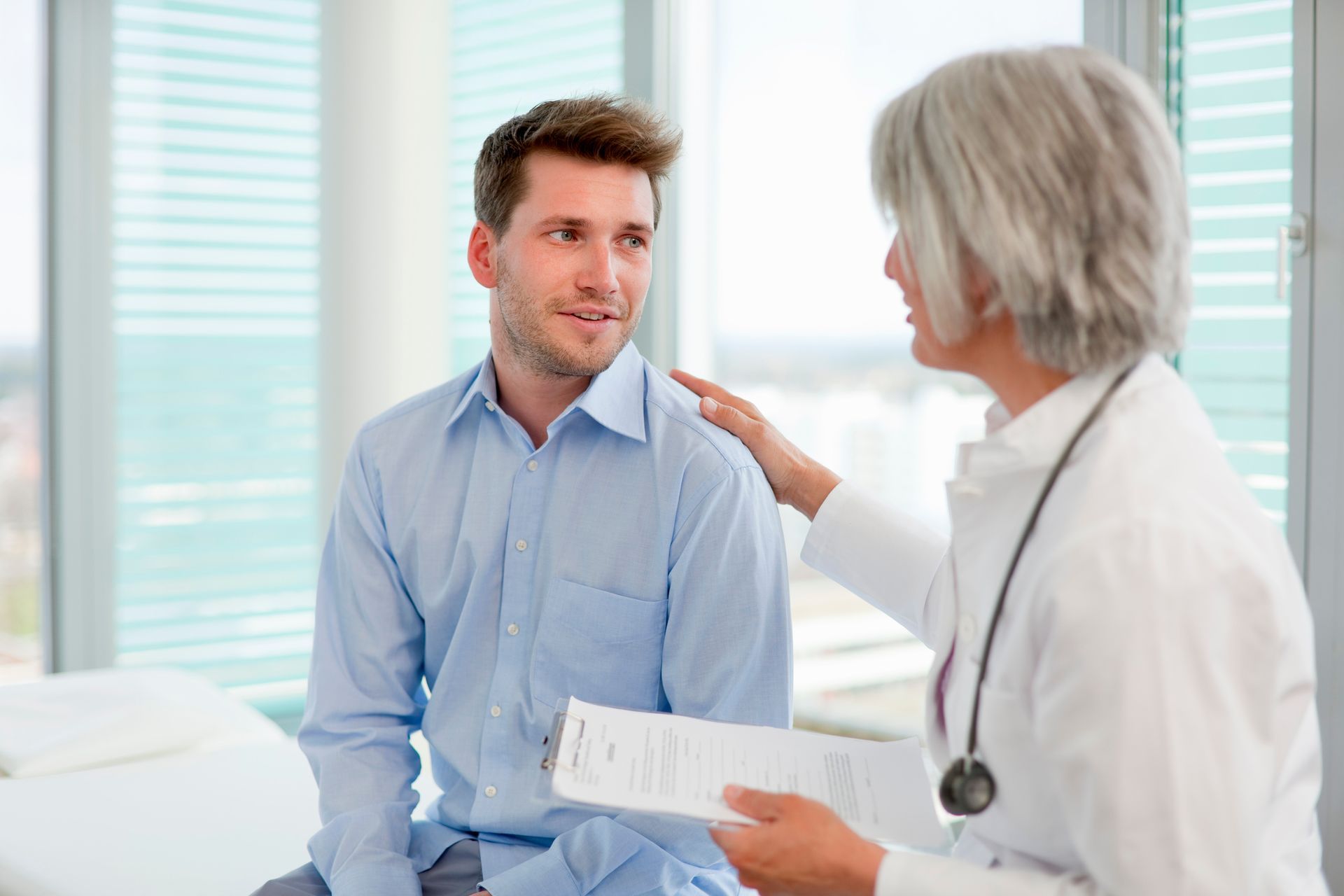 Female doctor talking to man in office for a commercial driver medical assessment. Female doctor talking to man in office for a commercial driver medical assessment.