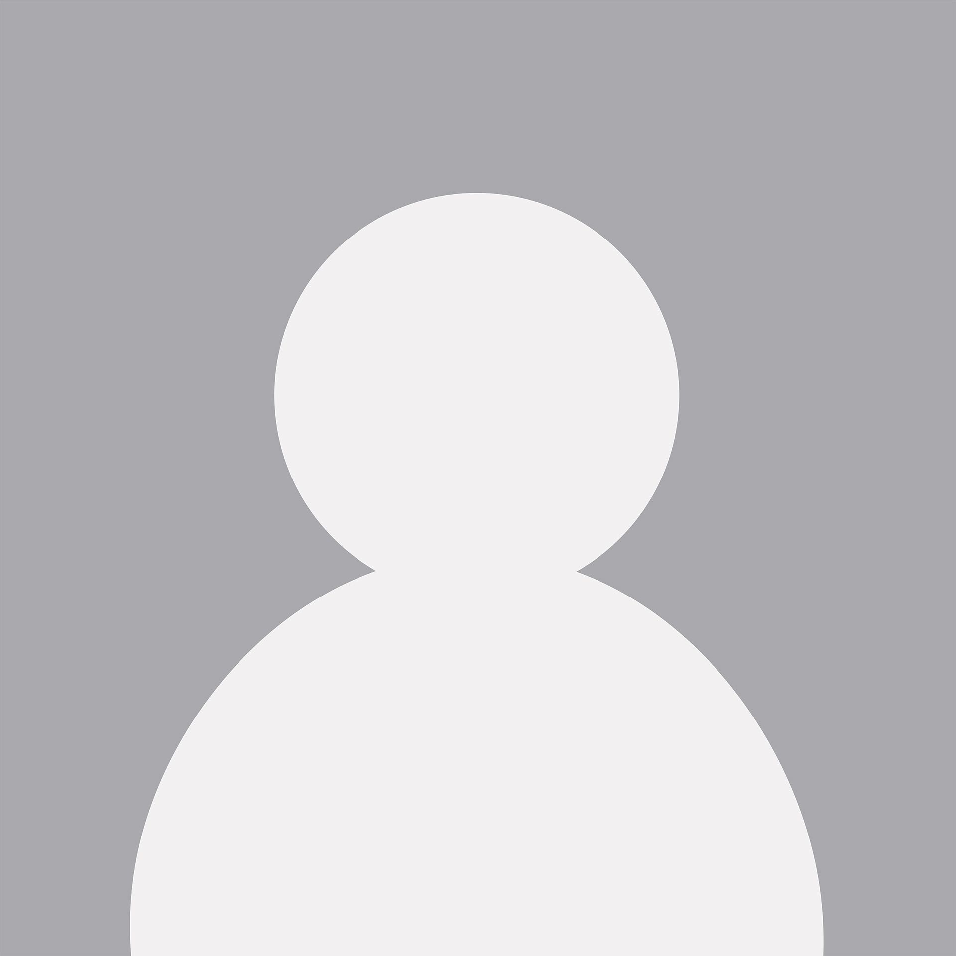 Woman hugs another woman, helping her write at a table with a laptop. Both are smiling.