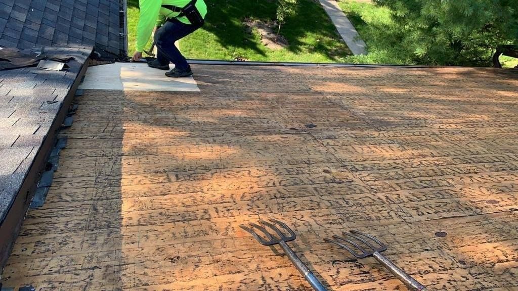 A man is working on the roof of a house.