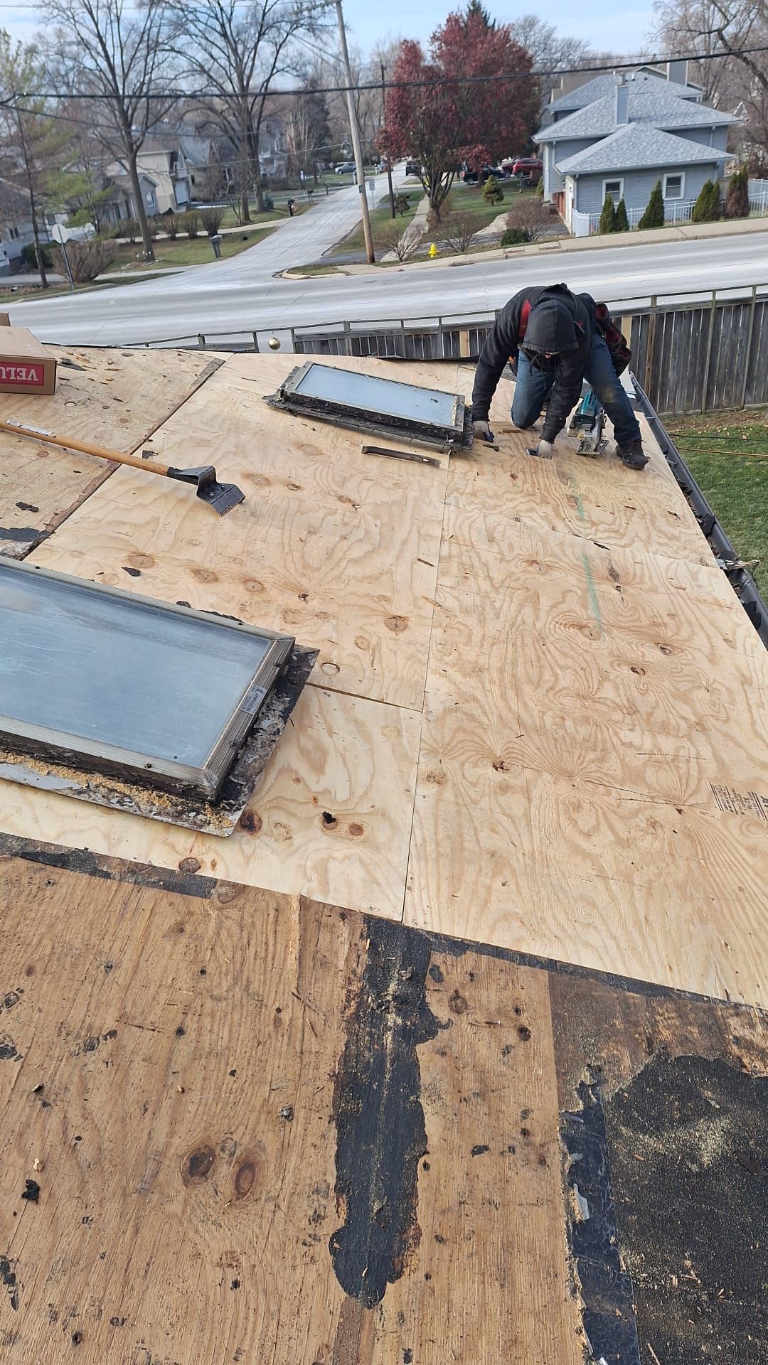 A man is working on the roof of a house.