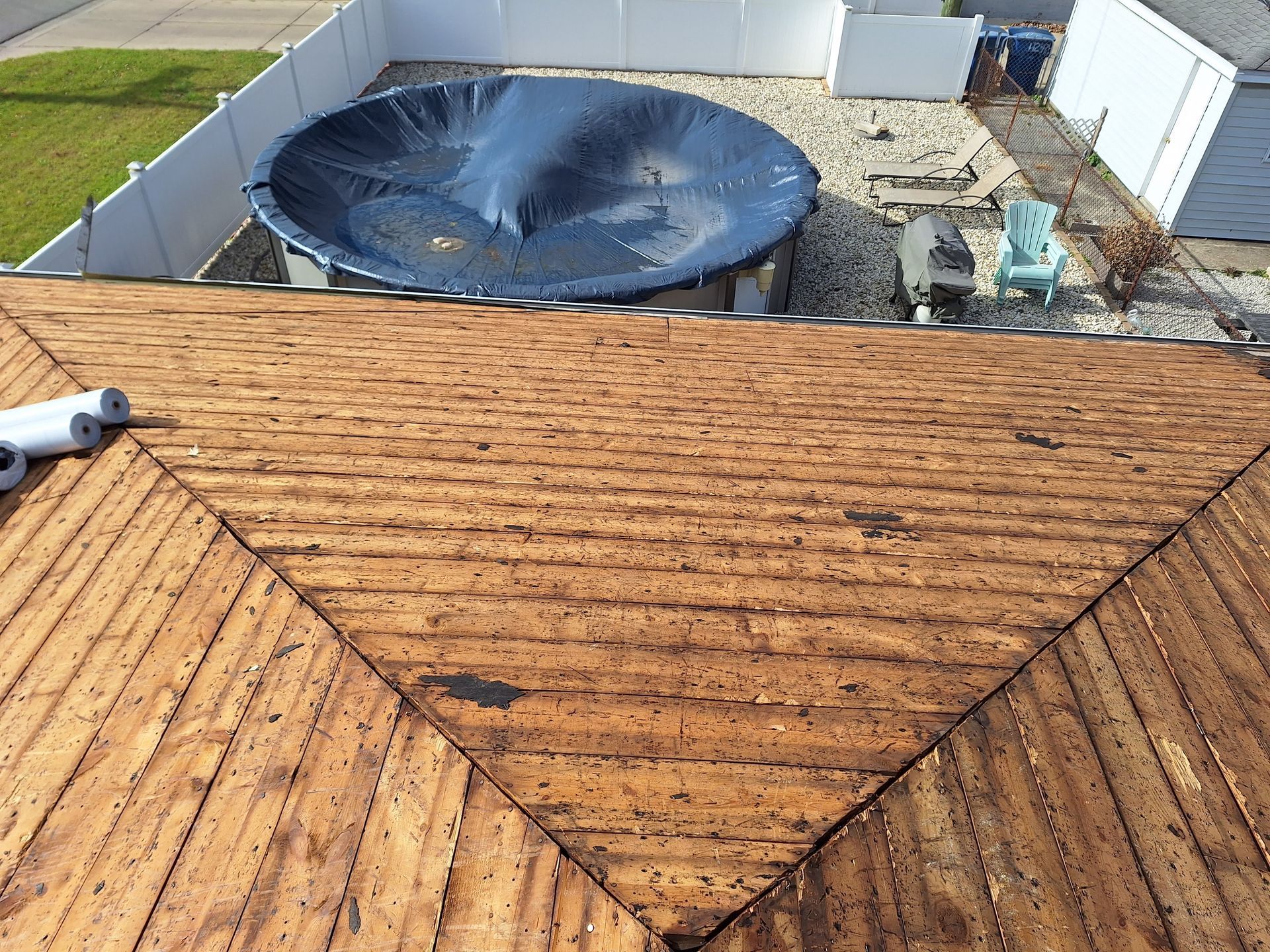 A hot tub is sitting on top of a wooden roof.