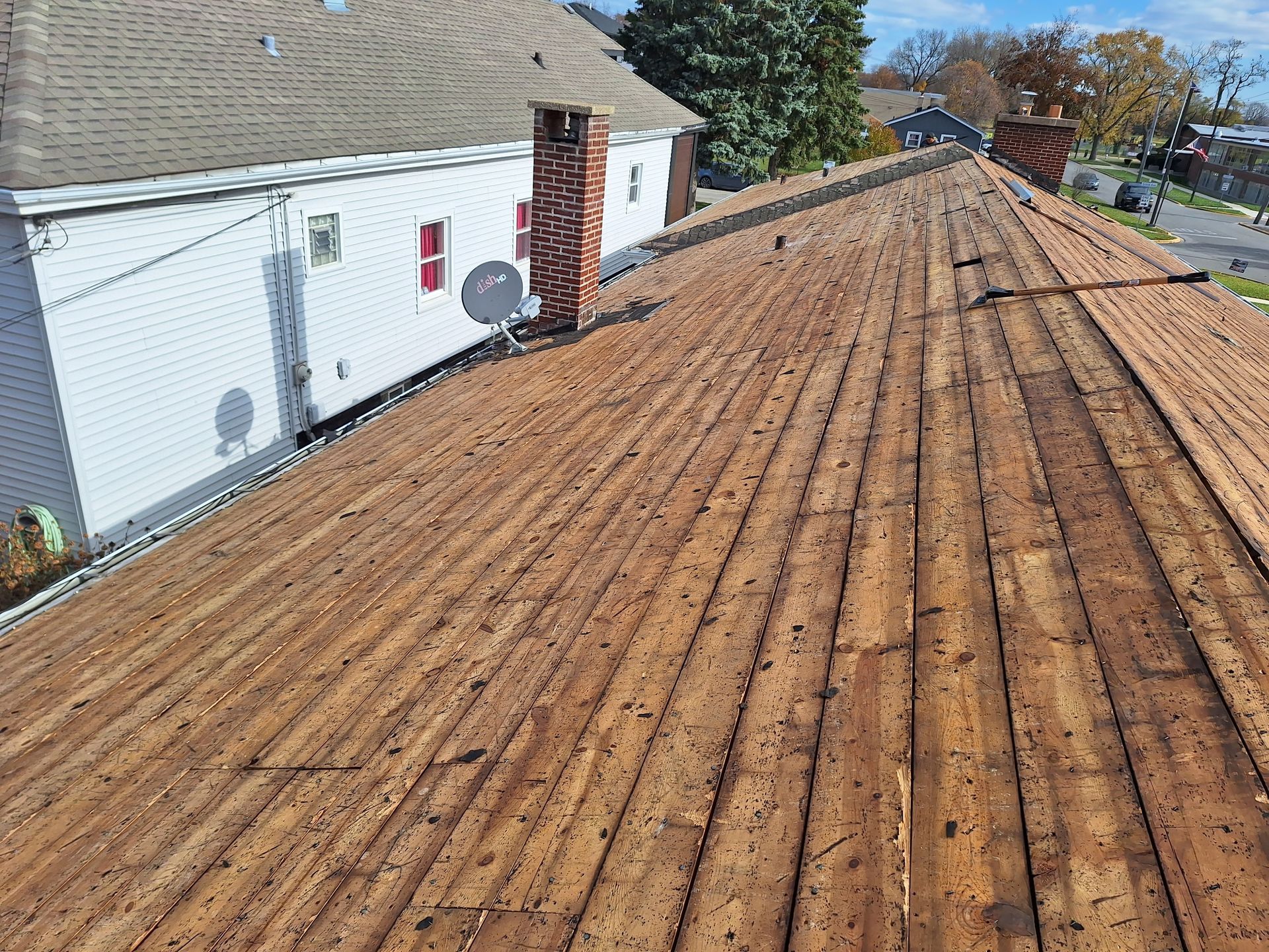 A wooden roof with a chimney on the side of a house.