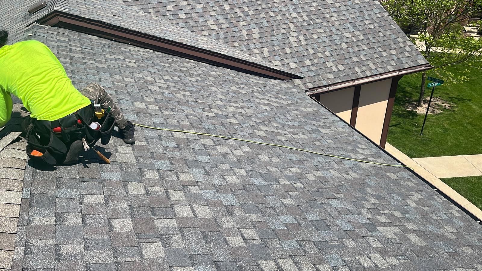 A man is working on the roof of a house.