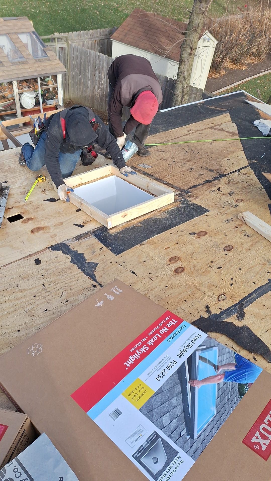 A couple of men are working on a roof.