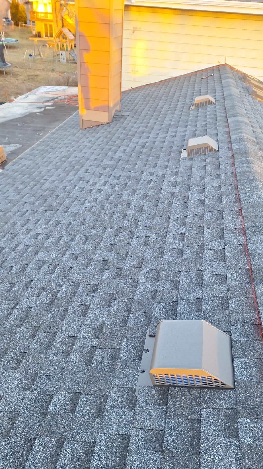 A close up of a roof with a chimney on it.