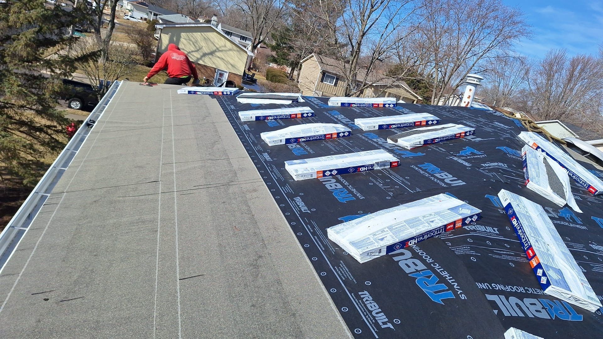 A man is working on the roof of a house.
