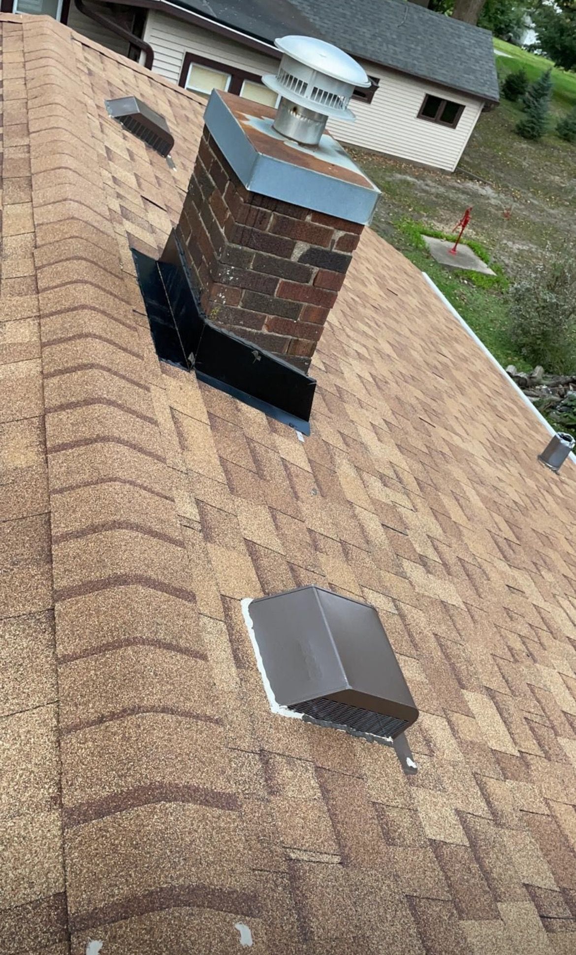 There is a chimney on the roof of a house.