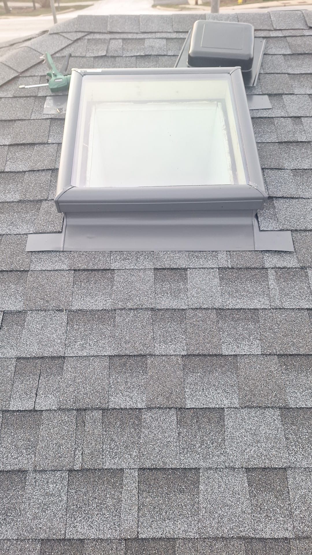 A skylight is sitting on top of a roof.