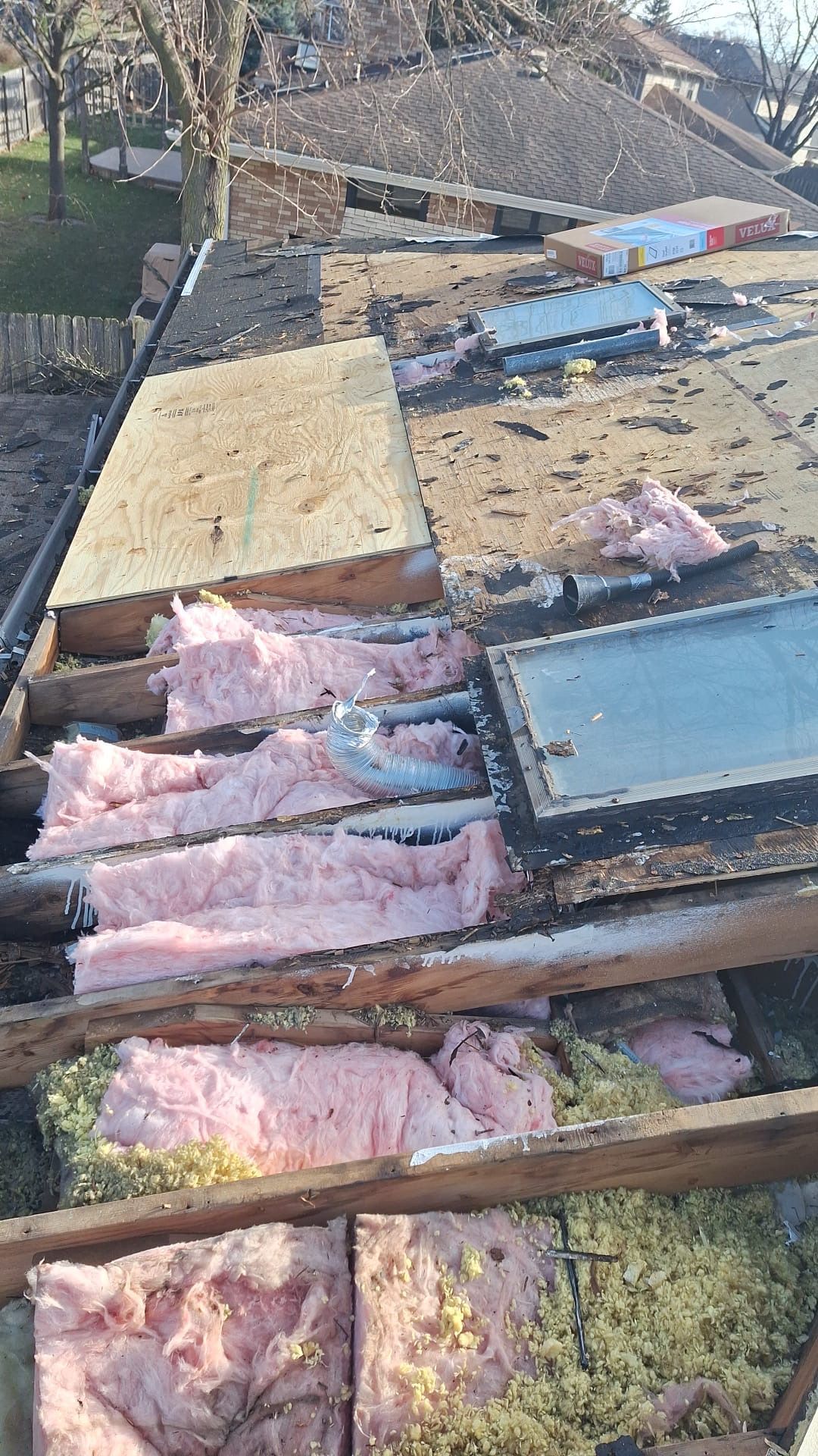 A roof with a lot of insulation on it and a skylight.