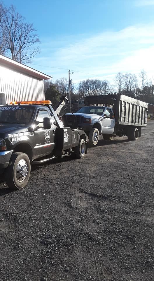 Two tow trucks are parked next to each other in a parking lot.