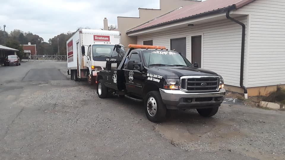 A black tow truck is parked in front of a building