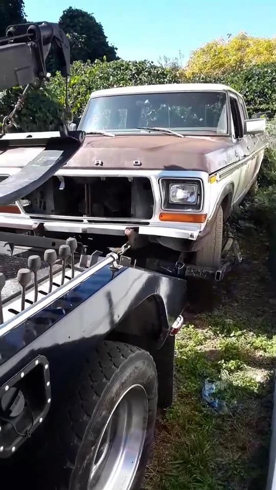 A truck is being towed by a tow truck.