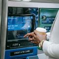 Person using an ATM touchscreen to withdraw cash