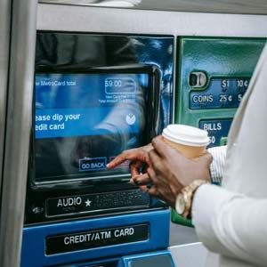 Person using an ATM touchscreen to withdraw cash