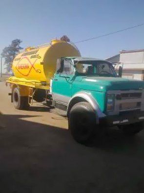 Un camión amarillo y verde está estacionado al costado de la carretera.