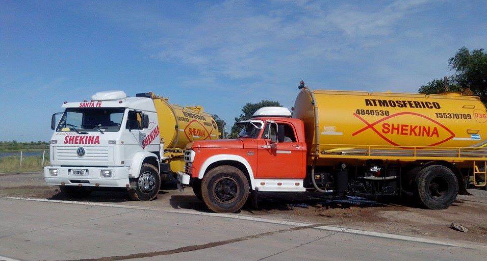 Dos camiones shekina están estacionados uno al lado del otro al costado de la carretera.