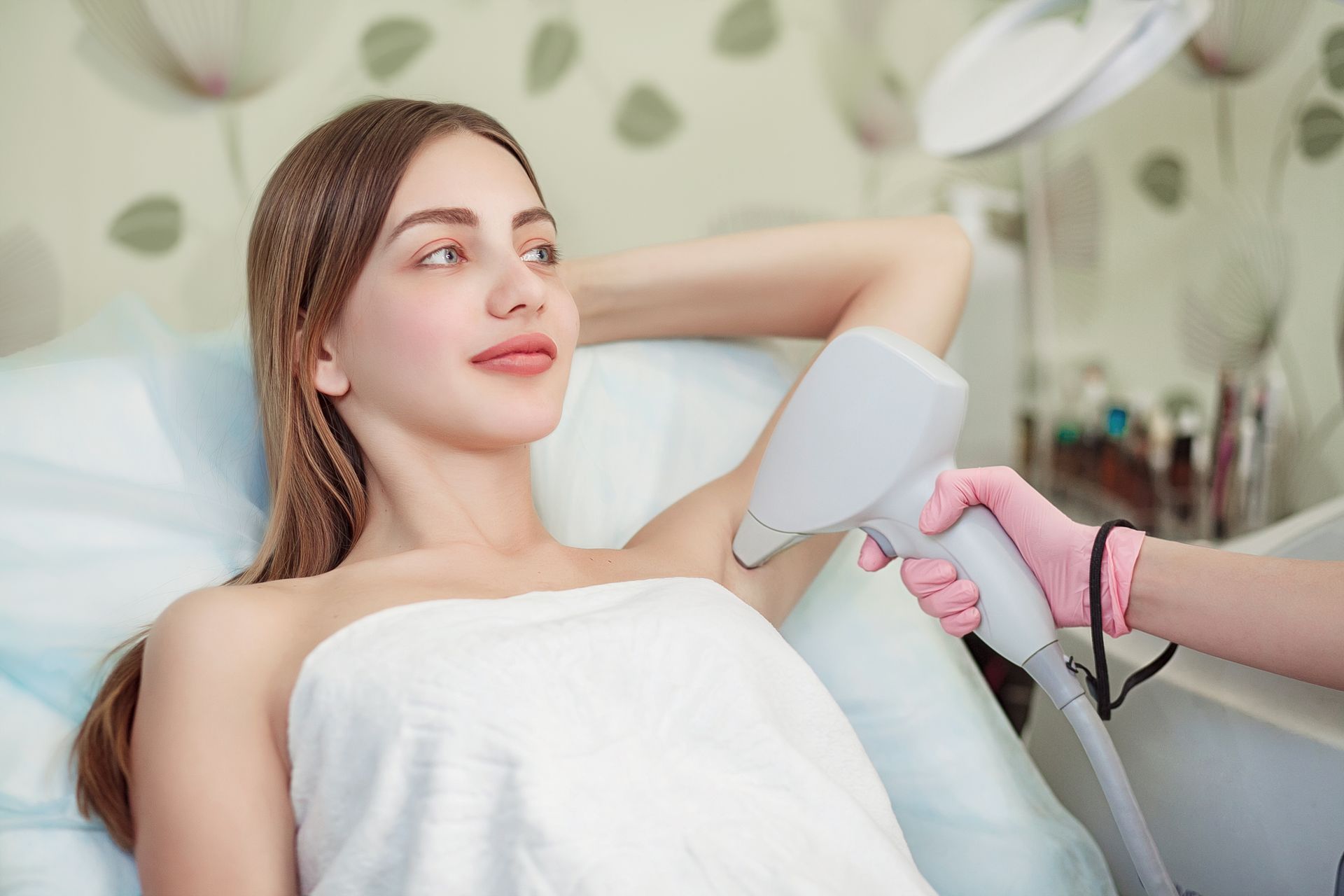 A woman is getting her underarm hair removed in a beauty salon.