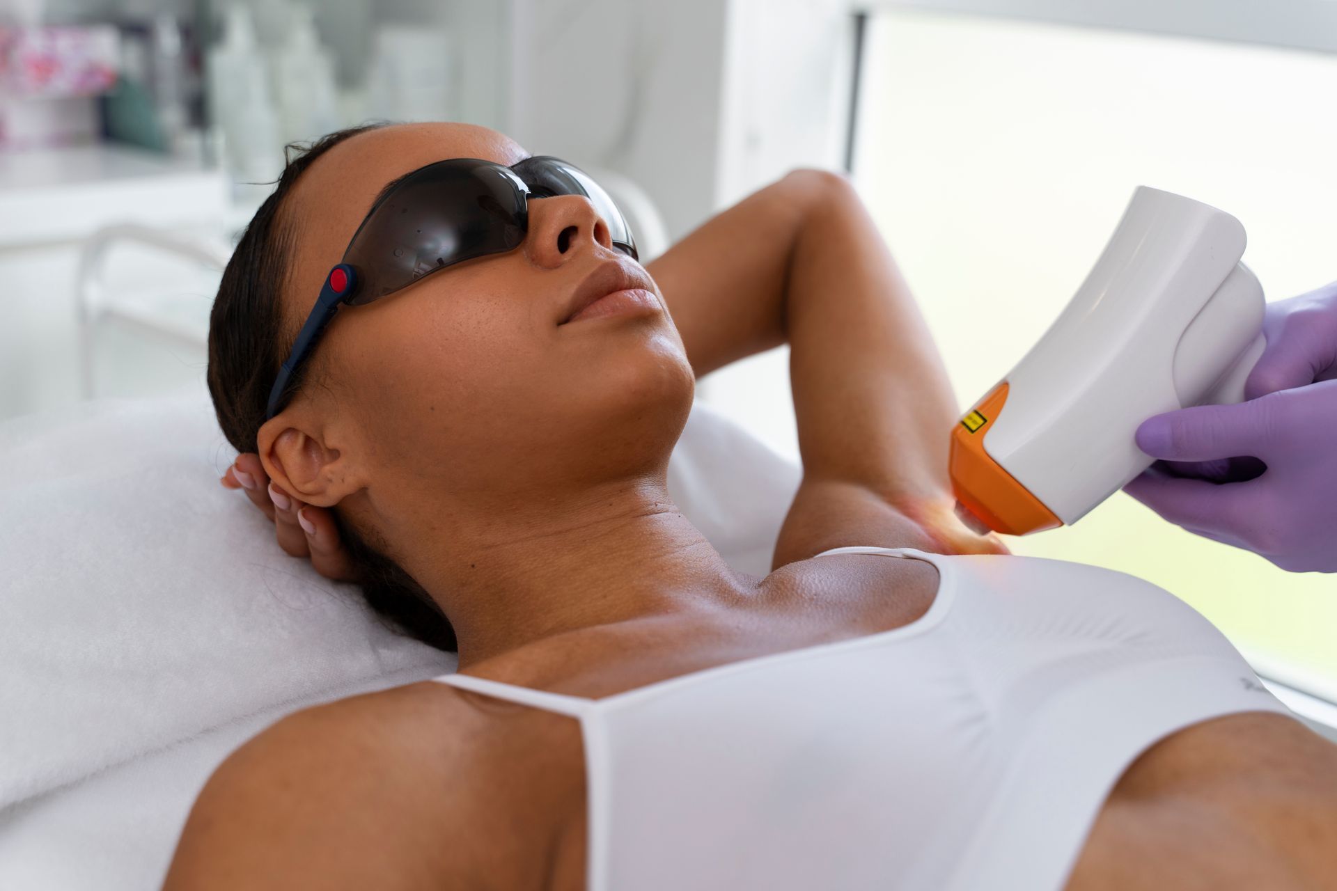 a woman is getting a laser hair removal treatment on her armpit .