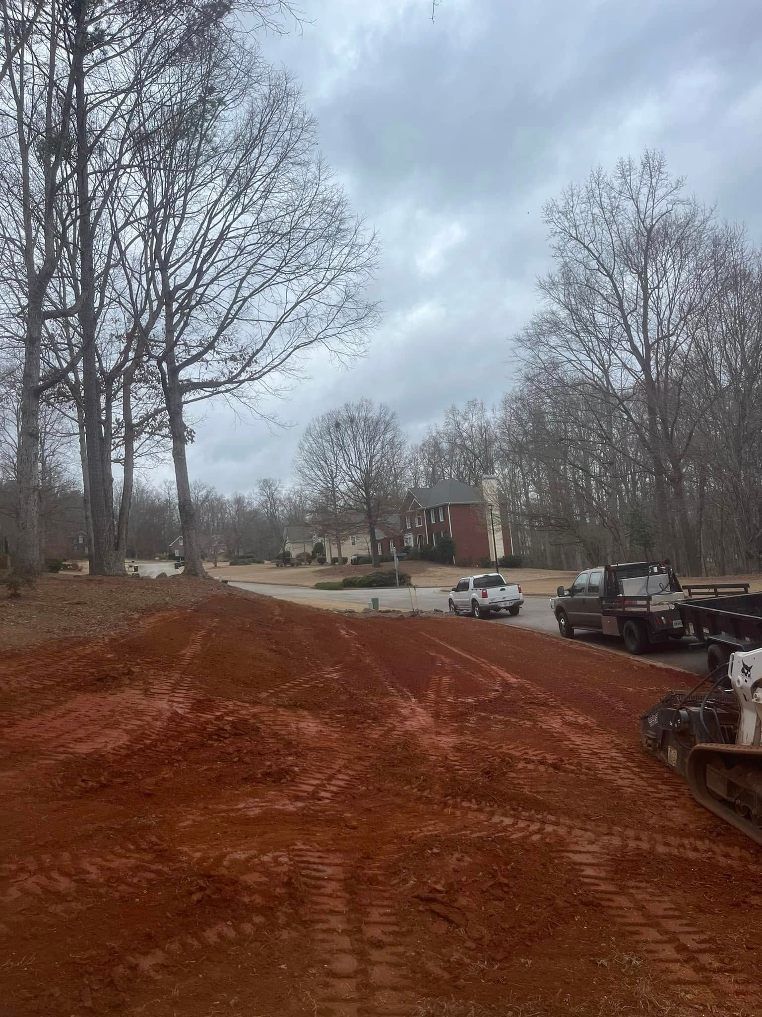 A construction site with a lot of dirt and trees in the background.