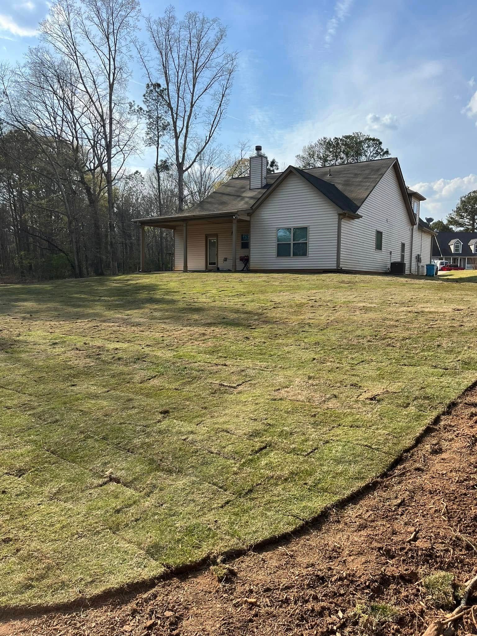A house is sitting on top of a grass covered hill.