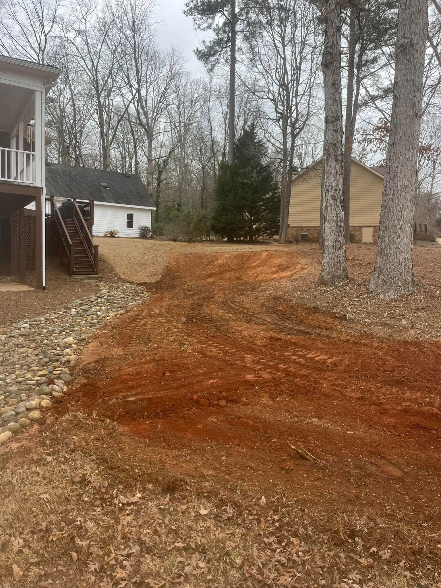 A house is sitting on top of a hill next to a large pile of dirt.