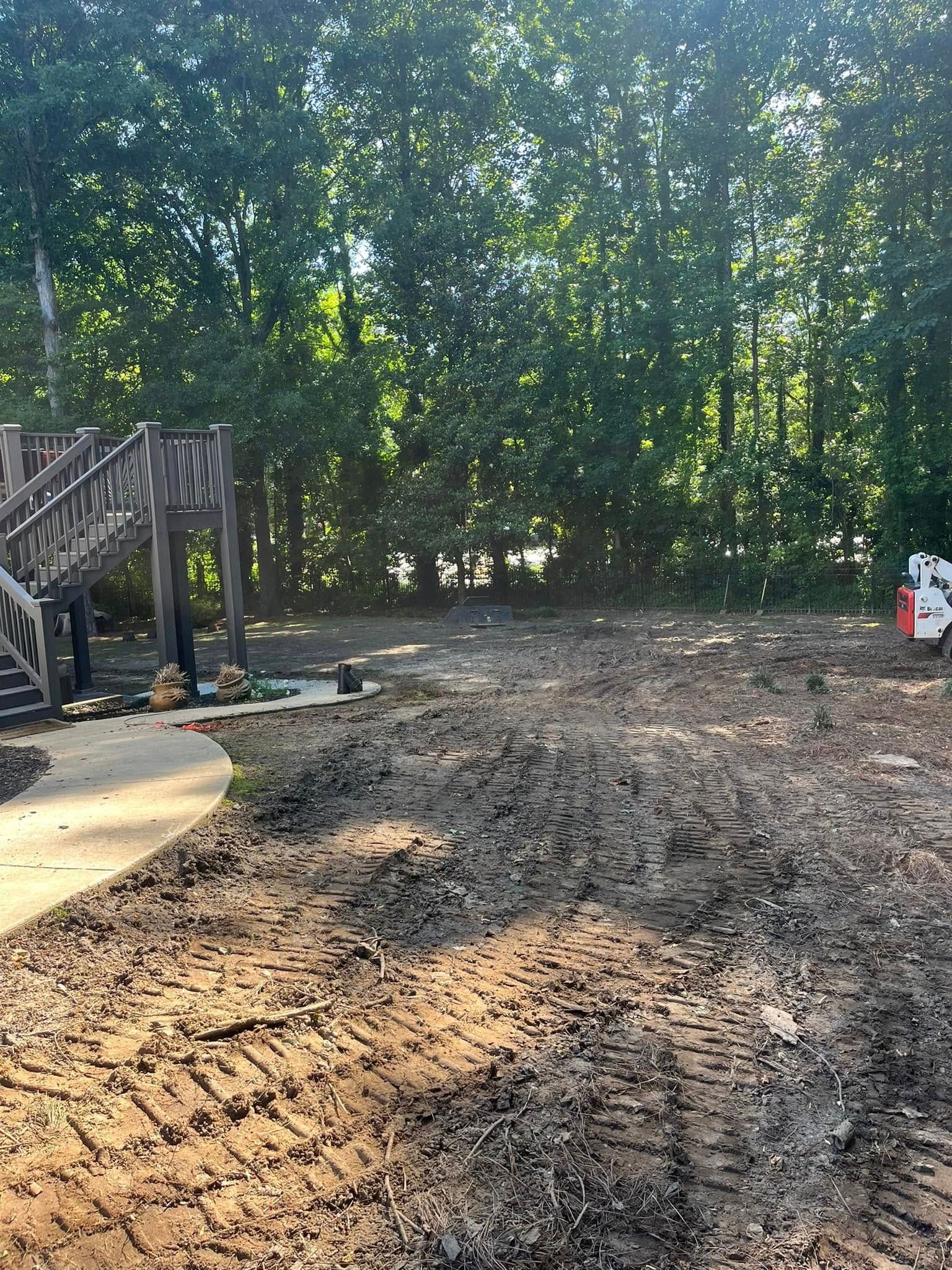 A large dirt field with a bridge in the background.