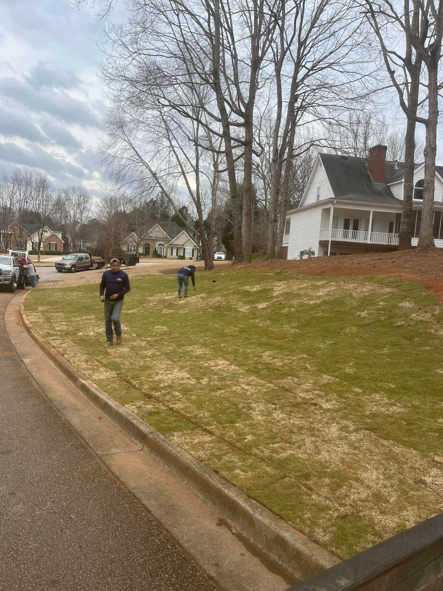 A man and a dog are walking down a sidewalk next to a house.
