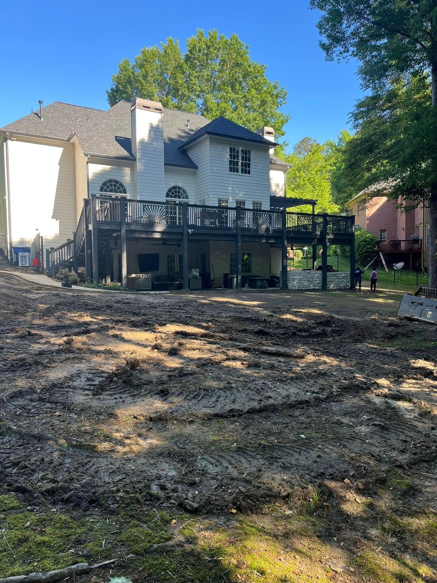 A large white house with a large deck in the backyard.