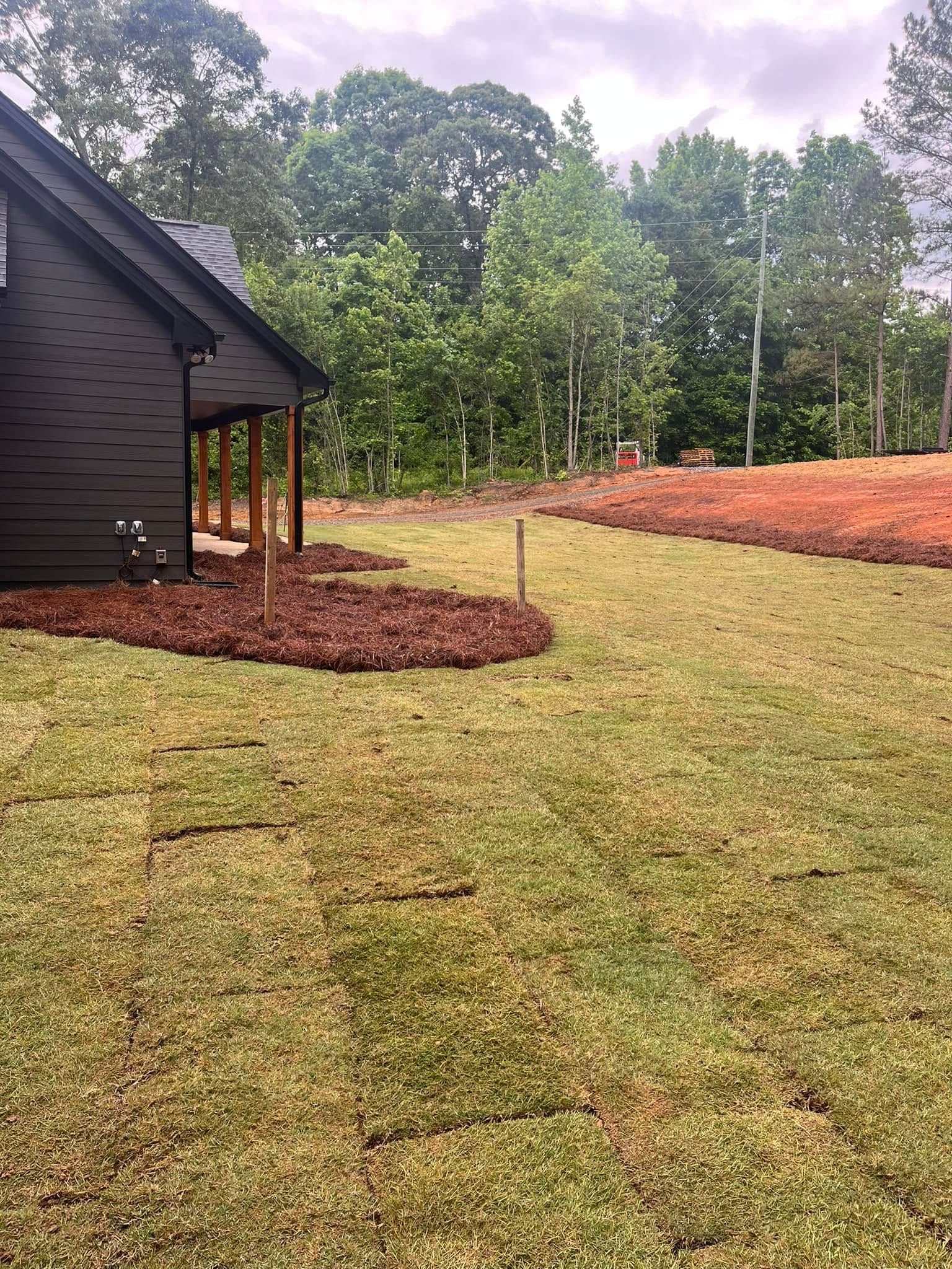 A house is sitting in the middle of a lush green field.
