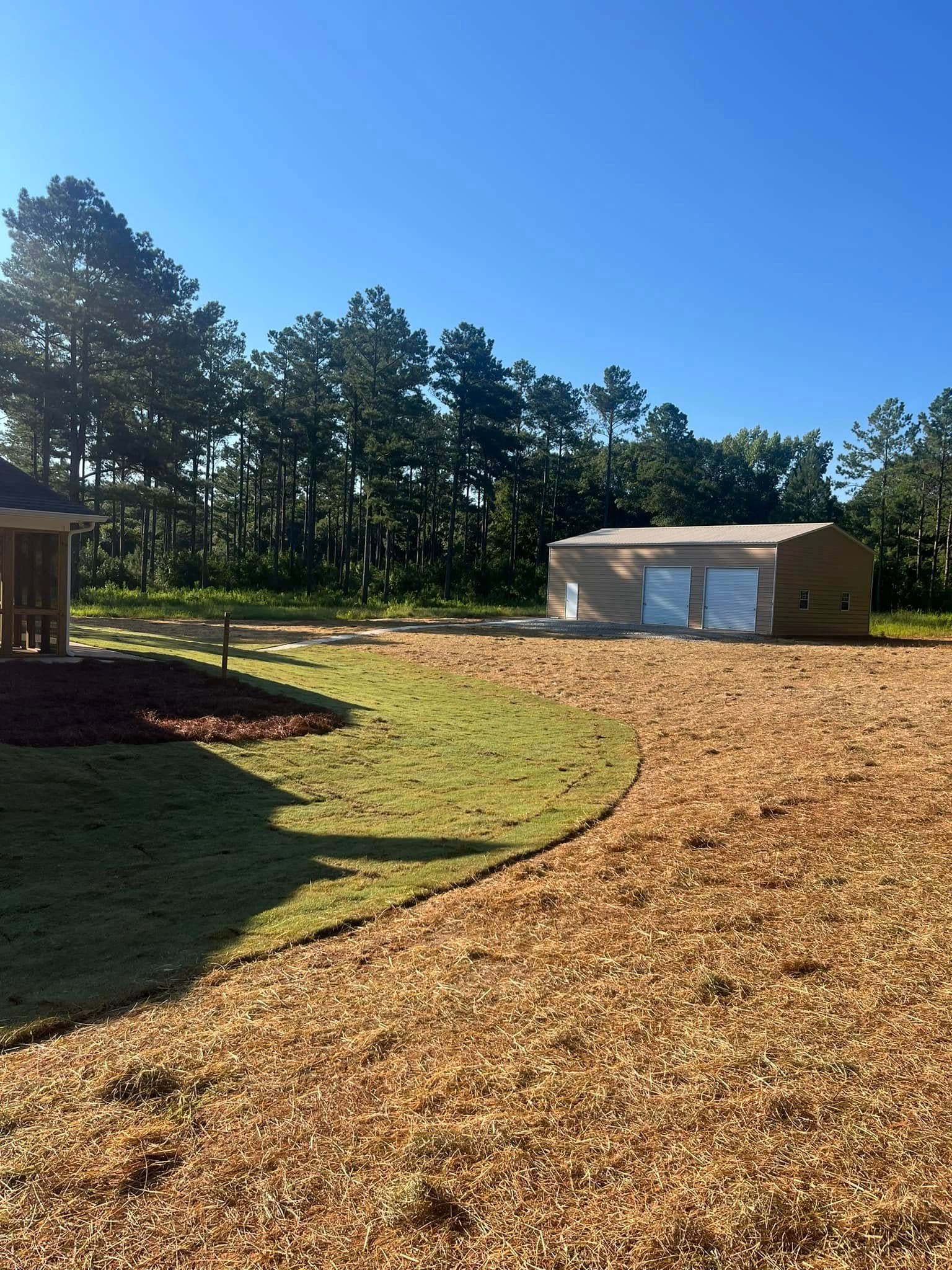 A house is sitting in the middle of a lush green field.