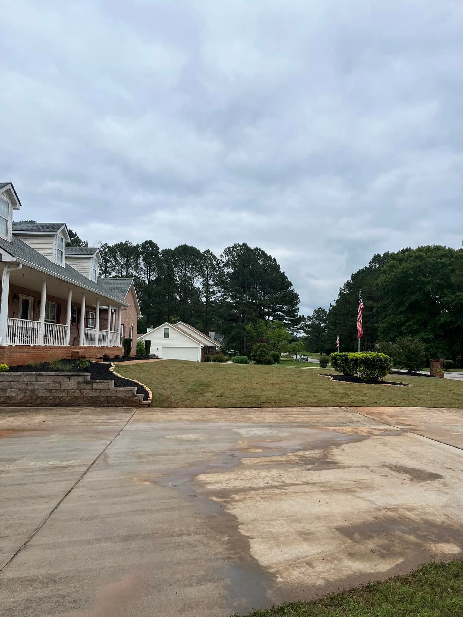 A large house with a porch and a flag in front of it.