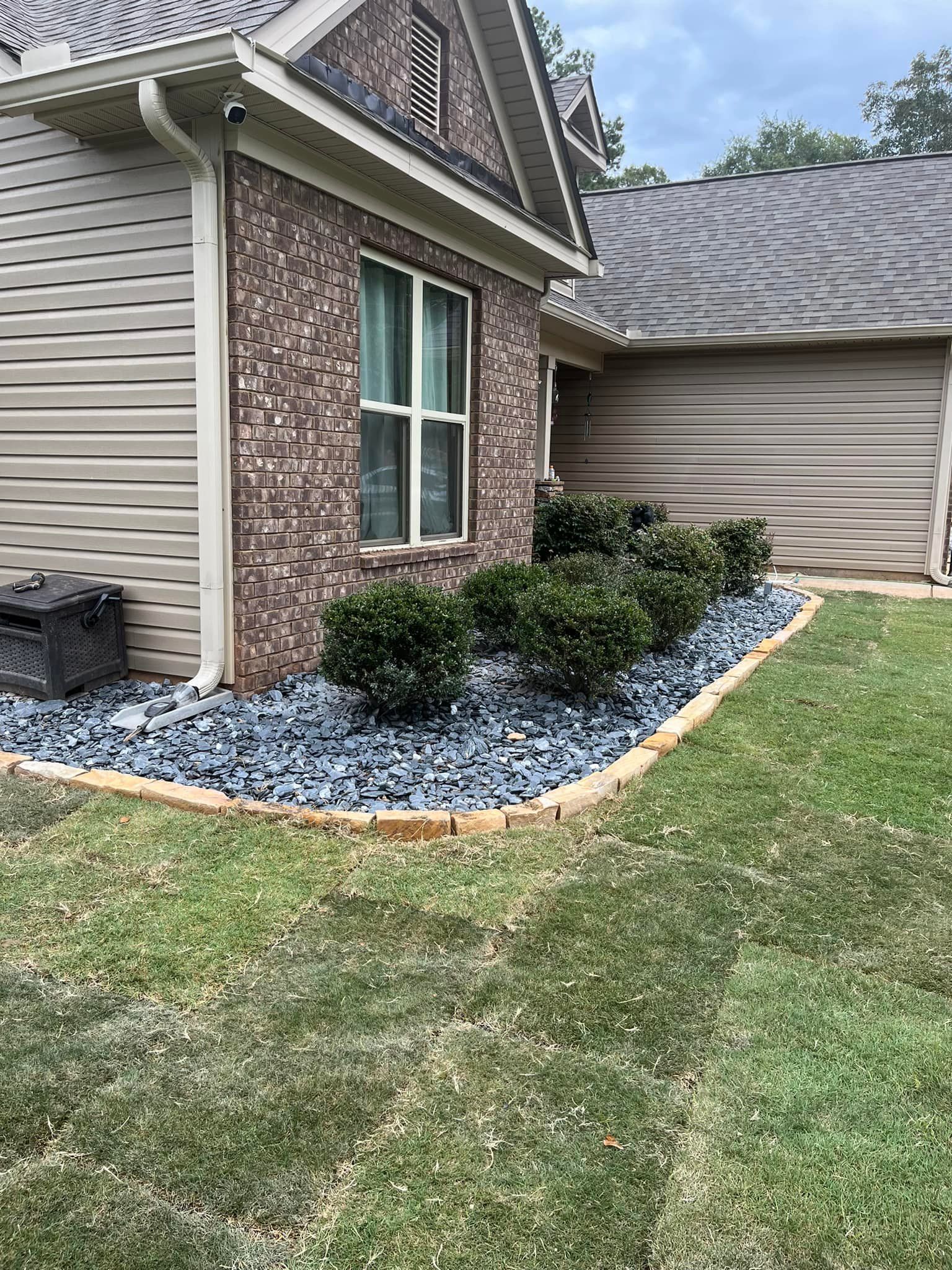 A brick house with a garden in front of it.