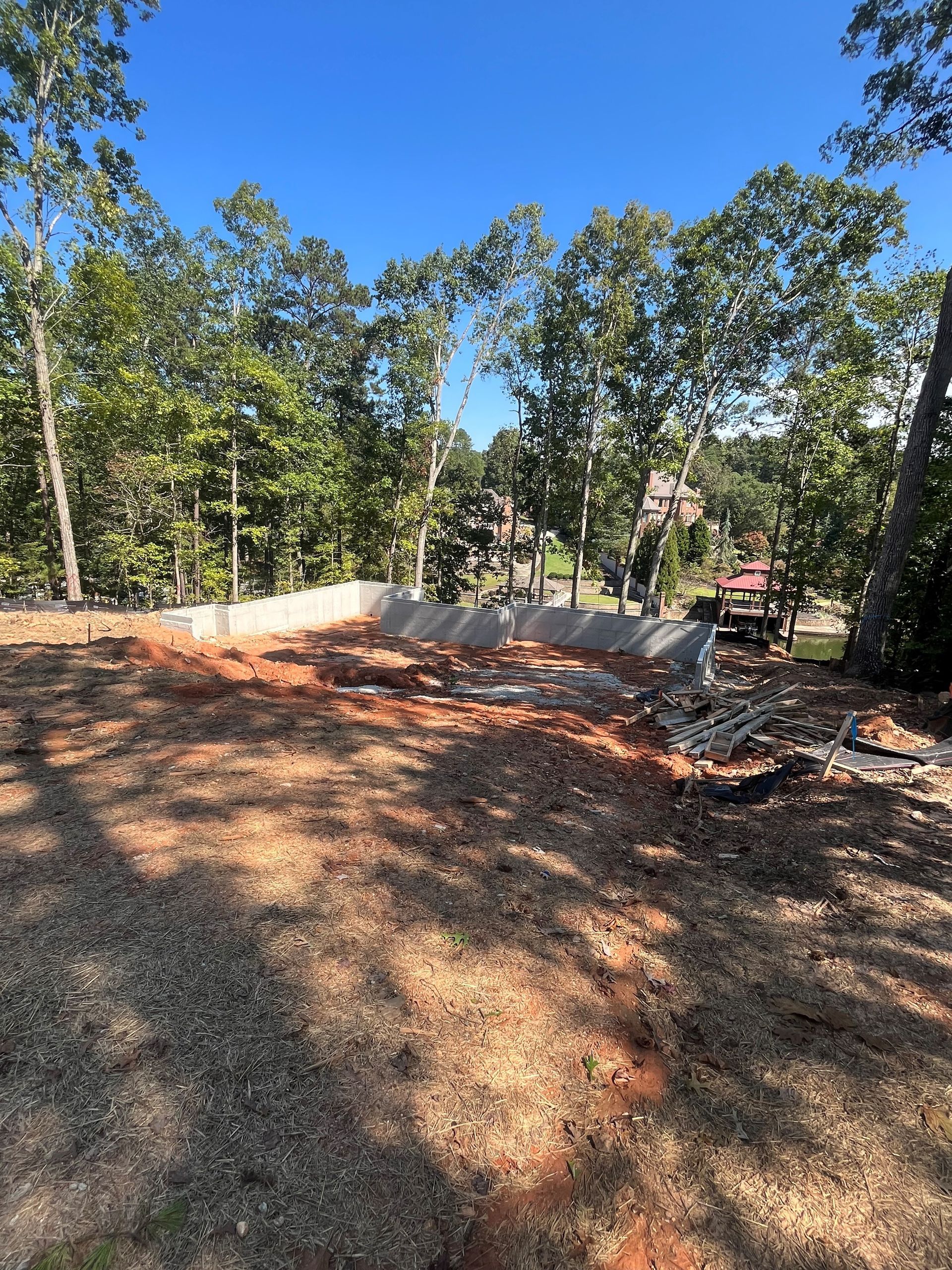 A dirt field with trees in the background and a blue sky in the background.