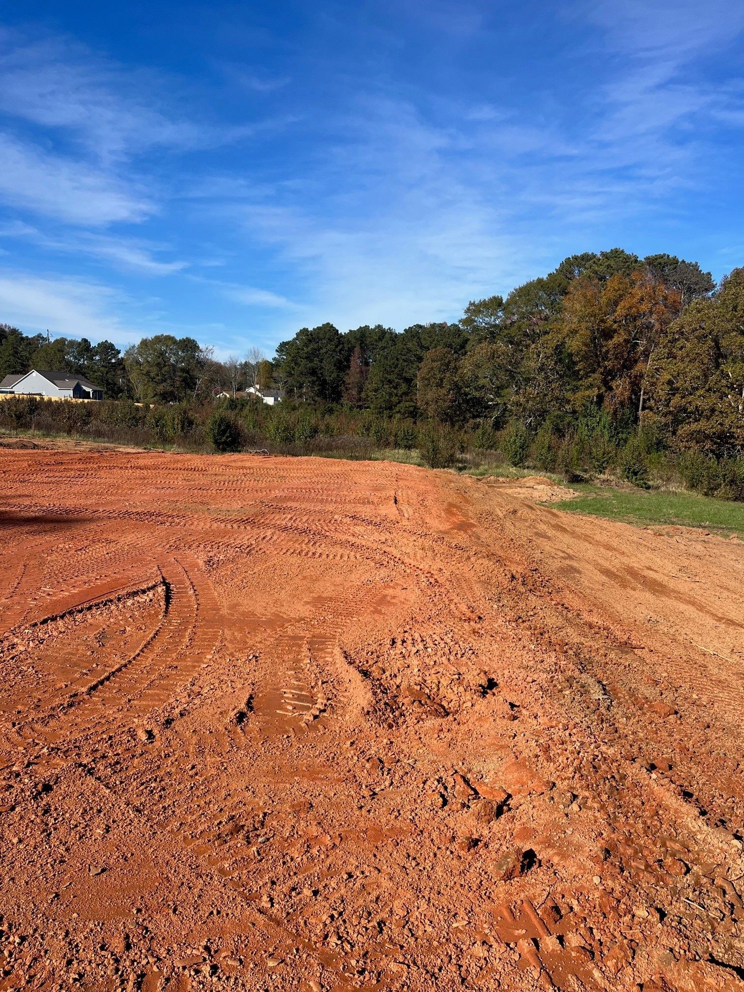 A dirt road with trees in the background on a sunny day.
